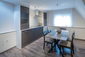 a kitchen and dining room with a table and chairs at Logies De blauwe regen in Beveren