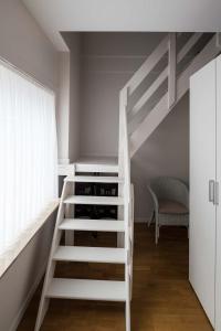 a white loft bed with wine bottles in a room at Logies De blauwe regen in Beveren