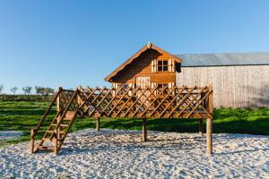 a wooden play structure in front of a small house at Monte da Casa do João - Exclusive, private & fully serviced in Grândola