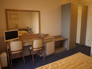 a hotel room with a desk and a mirror at Vila Marija-Roza in Drage