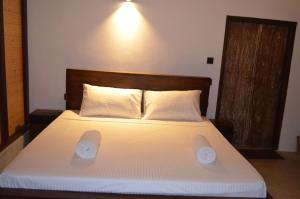 1 dormitorio con 1 cama con 2 almohadas en Agro Village Resort , Kalpitiya en Kalpitiya