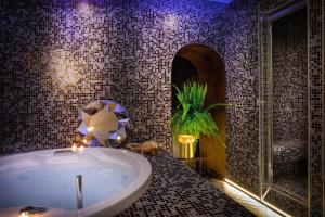 
a bath tub with a statue of a man in it at Dharma Boutique Hotel & SPA in Rome
