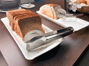 twee witte borden met sneetjes brood en lepels bij Pousada Sol e Mar Ingleses in Florianópolis
