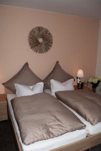 1 dormitorio con 2 camas y espejo en la pared en Hotel- Restaurant Kerzan´s, en Dortmund