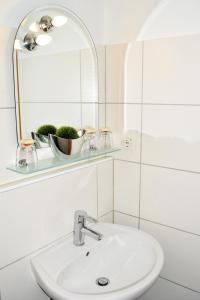 W białej łazience znajduje się umywalka i lustro. w obiekcie Hotel- Restaurant Kerzan´s w Dortmundzie