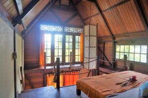 an attic room with a bed and a window at Yellow Houses Bocas DUPLEX in Bocas Town