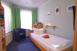Habitación pequeña con cama y silla en Esprit Hotel, en Halle an der Saale