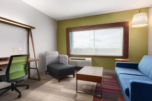 ein Wohnzimmer mit einem blauen Sofa und einem Stuhl in der Unterkunft Holiday Inn Express & Suites Edinburg- Mcallen Area, an IHG Hotel in Edinburg