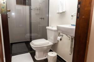 a bathroom with a toilet and a shower and a sink at Pousada Casa da Pedra in Blumenau