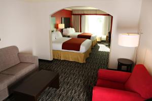 a hotel room with a bed and a couch at Holiday Inn Express Hotel & Suites - Sumter, an IHG Hotel in Sumter
