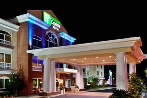 um exterior de hotel à noite com uma placa iluminada em Holiday Inn Express Hotel & Suites - Sumter, an IHG Hotel em Sumter