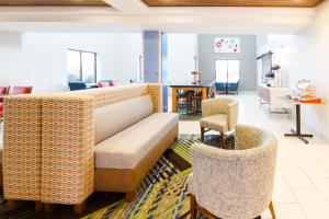 Holiday Inn Express & Suites Shelbyville, an IHG Hotel في شيلبيفيل: غرفة معيشة مع أريكة وكراسي