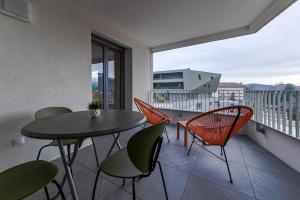 - un balcon avec une table et des chaises dans l'établissement L'Estrade La Costière - 2 chambres avec vue sur le Lac, à Annecy