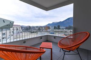d'un balcon avec deux chaises et une vue sur les montagnes. dans l'établissement L'Estrade La Costière - 2 chambres avec vue sur le Lac, à Annecy