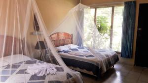 a bedroom with a bed with a mosquito net at Hotel Tikal Inn in Tikal