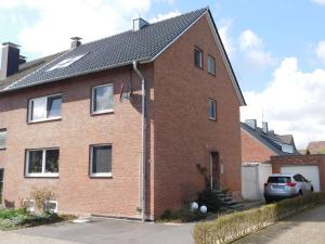 a brick house with a car parked in front of it at Angelika Ferienwohnung in Rhede