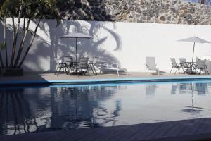 grupa krzeseł i parasoli obok basenu w obiekcie Hotel Love w mieście Temixco