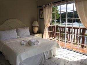 a bedroom with a bed and a large window at Marigot Beach Club & Dive Resort in Marigot Bay