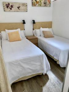 two beds sitting next to each other in a room at HomeForGuest Cozy loft with parking next to the Arucas Cathedral in Arucas