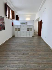 an empty room with white cabinets and a wooden floor at HomeForGuest Cozy loft with parking next to the Arucas Cathedral in Arucas