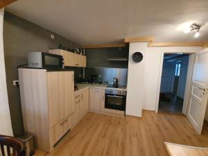 cocina con armarios de madera y microondas en Ferienwohnung Ines Wolf in der Meißner Innenstadt, en Meißen