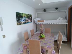 een eetkamer met een tafel en een stapelbed bij Apartamentos Blaucel in Deltebre