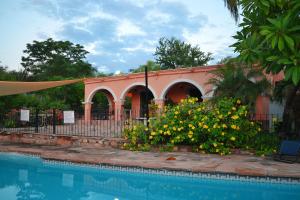 un edificio con una piscina y flores al lado en Loma de Guadalupe Alamos Sonora, en Álamos