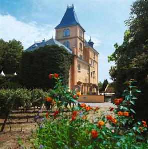 een gebouw met een toren met een bos bloemen bij Hotel Schloss Edesheim in Edesheim