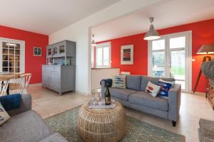 a living room with a couch and a table at Villa ty Oyats, face à l'océan nouveautés 2024 in Plouescat +23 photos