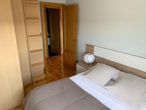 a bedroom with a bed and a room with shelves at Apto Alma Parking y Piscina GRATIS in Zaragoza