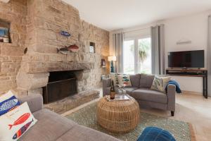 a living room with a large stone fireplace at Villa ty Oyats, face à l'océan nouveautés 2024 in Plouescat