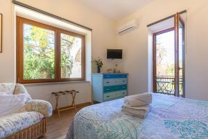 1 dormitorio con 1 cama, 1 sofá y 2 ventanas en Villa la Quercia en Meta