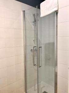 a shower with a glass door in a bathroom at Albergue O Burgo in O Pedrouzo