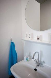 lavabo con espejo y toalla azul en Bed & Breakfast de Lindevallei, en Oldeberkoop