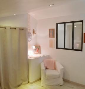 a bathroom with a shower and a chair and a window at LAMATHYE in Aramon