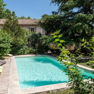 una piscina nel cortile di una casa di Hôtel Mas Vidau Porte des Alpilles a Saint-Étienne-du-Grès