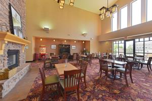 a restaurant with tables and chairs and a fireplace at Holiday Inn Express Hotel & Suites Gillette, an IHG Hotel in Gillette