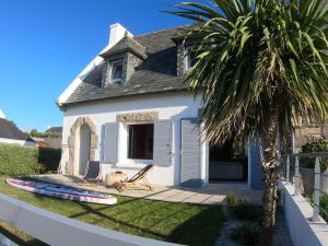 a house with a palm tree and a house with a surfboard at Villa ty Oyats, face à l'océan nouveautés 2024 in Plouescat