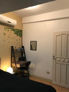 a bedroom with a bed and a desk and a door at Maria's House nearby Victory Town Center in Kay Riapay