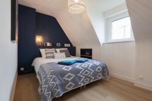 a bedroom with a bed with a blue accent wall at Villa ty Oyats, face à l'océan nouveautés 2024 in Plouescat
