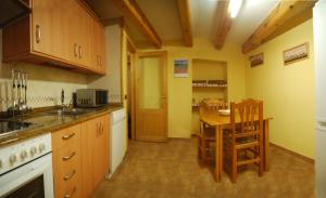 a kitchen with a table and a dining room at Casa La Catalina in Beceite