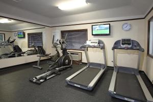 a gym with treadmills and exercise bikes and a clock at Holiday Inn Express Hotel & Suites Vernon, an IHG Hotel in Vernon