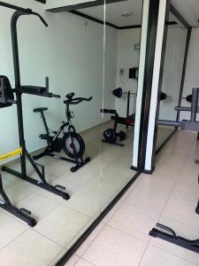 einen Fitnessraum mit mehreren Heimtrainern und einem Spiegel in der Unterkunft Boutique Gym Salon juegos Tv Oficina Sanitizada in Toluca de Lerdo