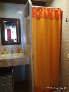 an orange shower curtain in a bathroom with a sink at El Cotillo Casa Checa 4 in El Cotillo +23 photos