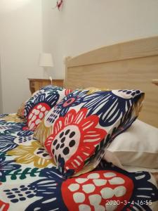 una cama con almohadas coloridas encima en El Cotillo Casa Checa 4, en Cotillo