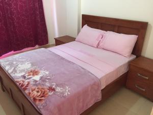 a bedroom with a bed with pink sheets and a pink blanket at ocean view apartment in Rabat