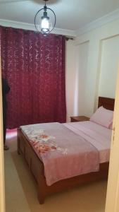 a bedroom with a bed and a purple curtain at ocean view apartment in Rabat