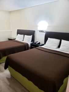 Habitación de hotel con 2 camas y almohadas blancas en Value Inn & Suites Salina en Salina