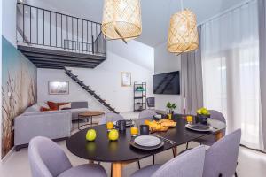 a living room with a dining table and chairs at VILLA REMUSIC Pool, whirlpool, Sauna,4 bedrooms, amazing landscape in Smolonje