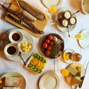 a table with plates of food and glasses of orange juice at Casa Leonardo in Senterada